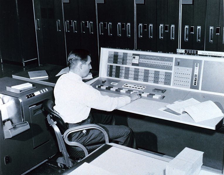 A meteorologist at the console of the IBM 7090 electronic computer in the Joint Numerical Weather Prediction Unit. This computer was used to process weather data for short and long-range forecasts, analyses, and research.
